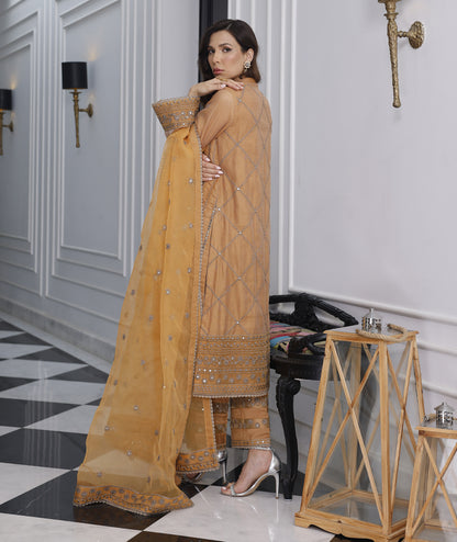 Elegant marigold khaddi net outfit with organza dupatta and raw silk trouser.